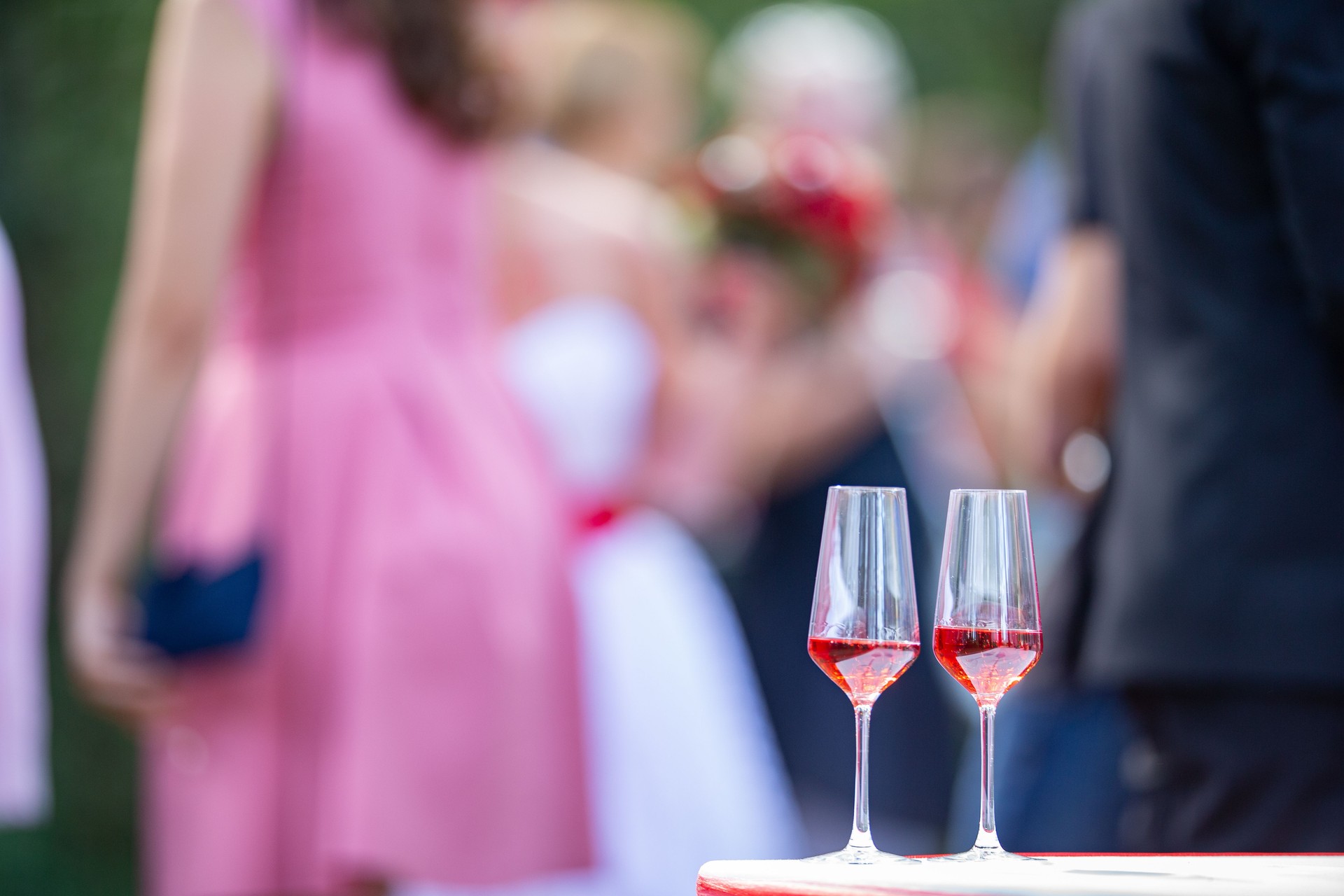 Two Flute Glasses Sitting on a Table at Summertime Wedding Waiting to Toast - Stock Photo